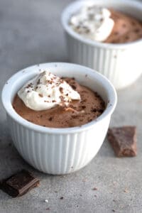 Two white dessert cups filled with creamy keto chocolate mousse.