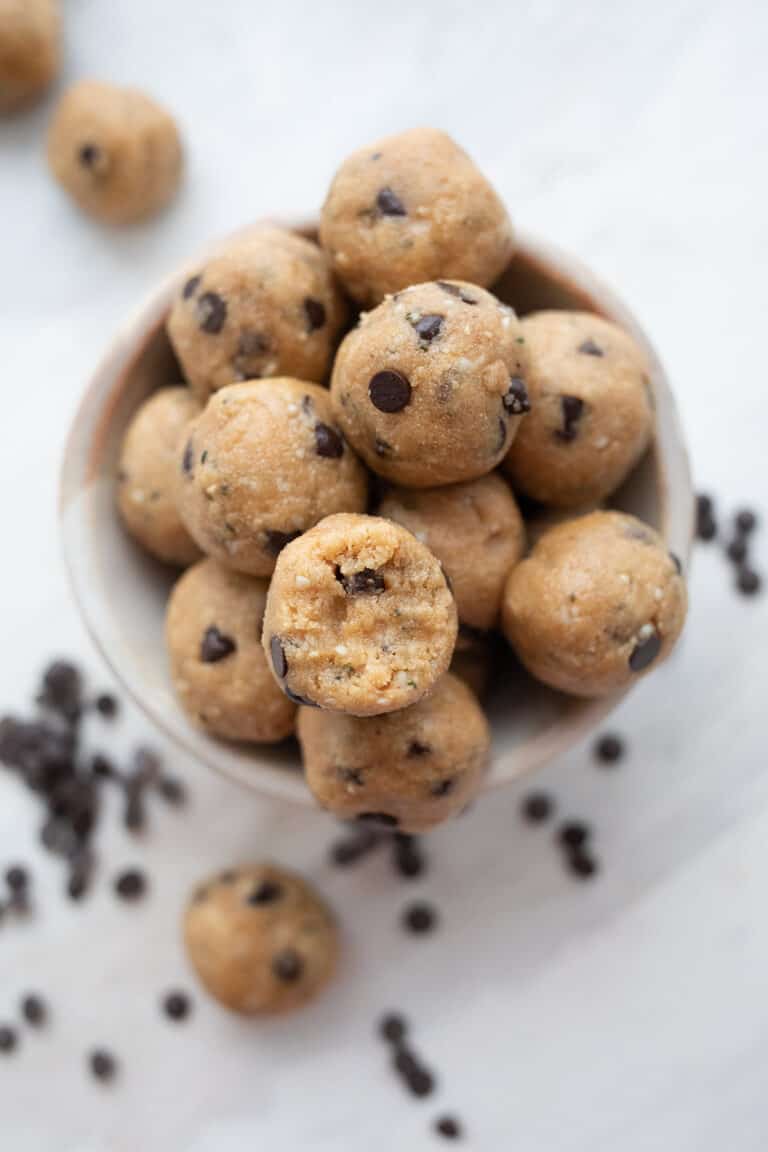 Top down image of a pile of keto peanut butter protein balls with a bite taken out of one.