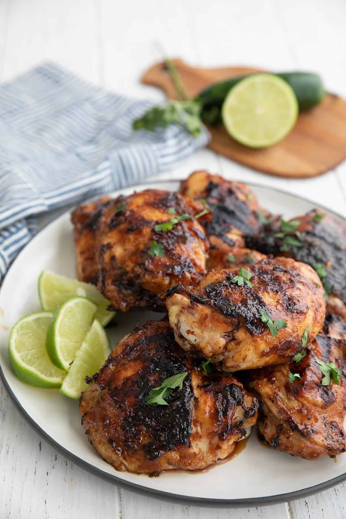 A plate of chipotle lime chicken thighs on a white table.