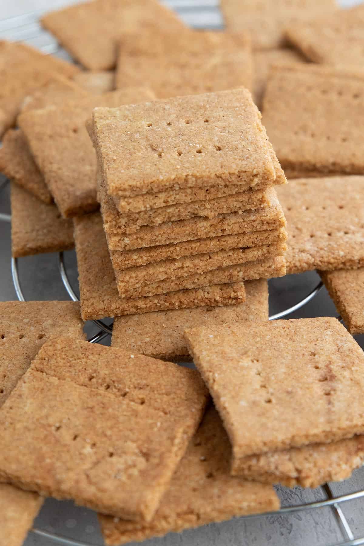 Keto graham crackers piled up on a cooling rack.