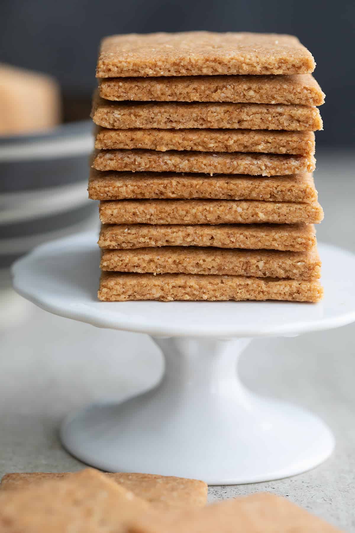 A stack of homemade sugar free graham crackers on a white cupcake stand.