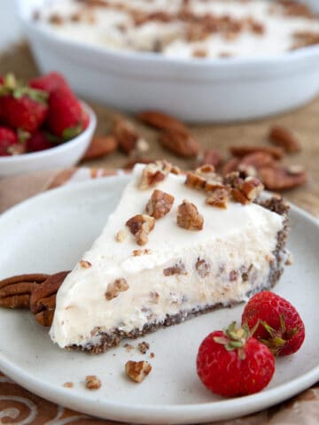 Keto Butter Pecan Ice Cream Pie on a white plate with strawberries.