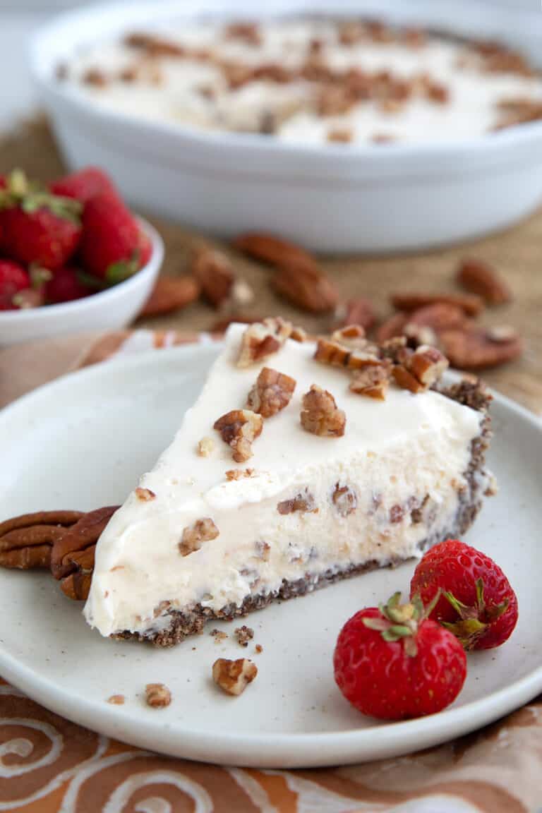 Keto Butter Pecan Ice Cream Pie on a white plate with strawberries.