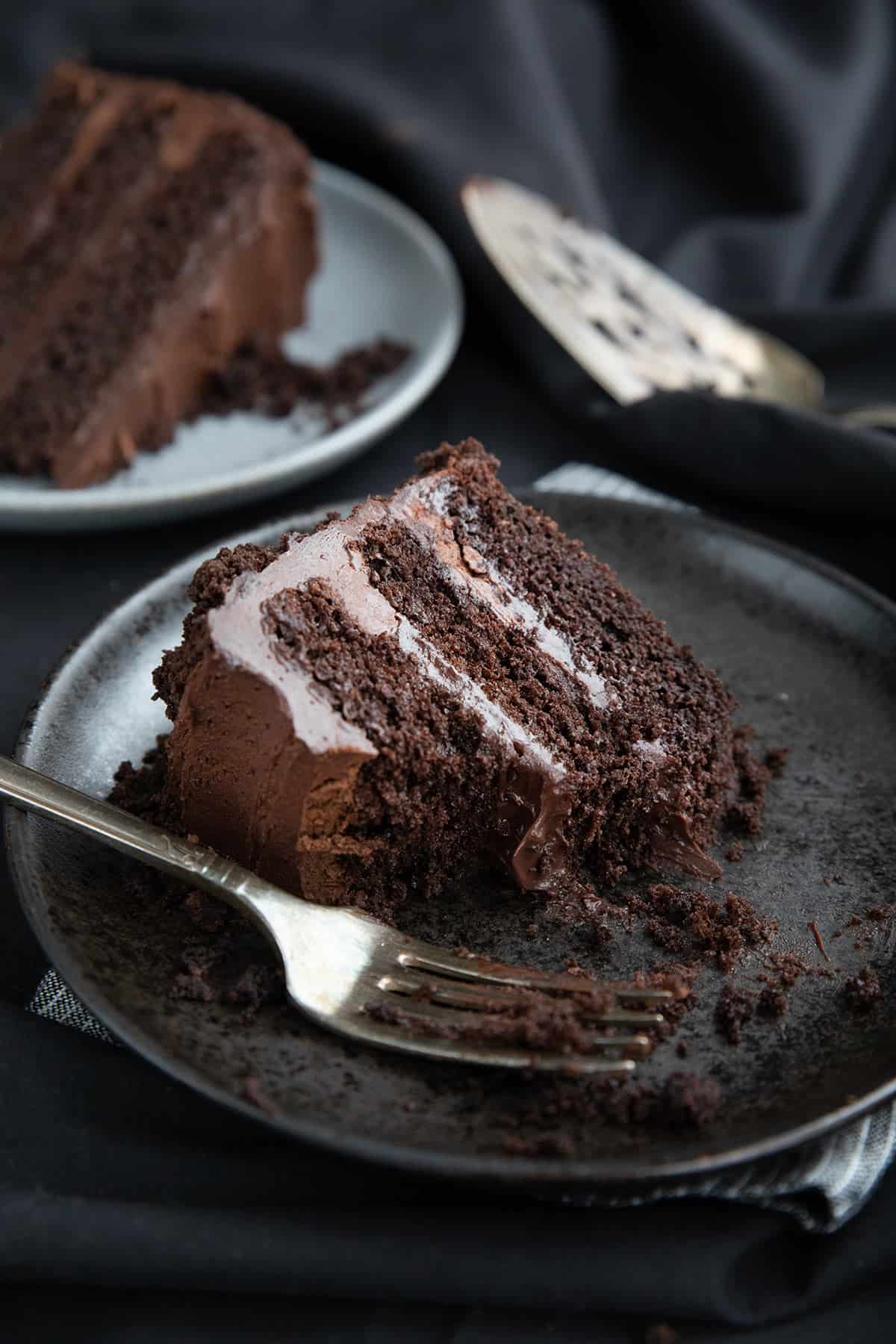 A slice of keto chocolate blackout cake with several bites taken out of it.