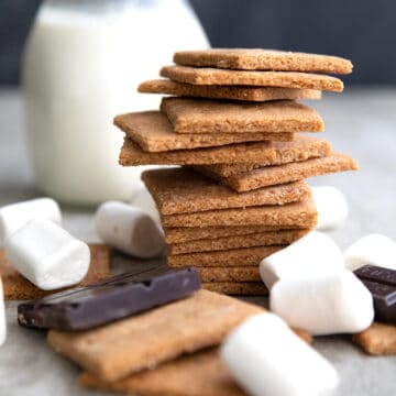 Sugar Free Graham Crackers in a stack with chocolate and marshmallows around it.
