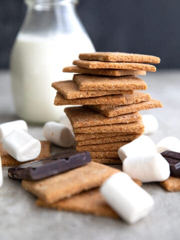 Sugar Free Graham Crackers in a stack with chocolate and marshmallows around it.