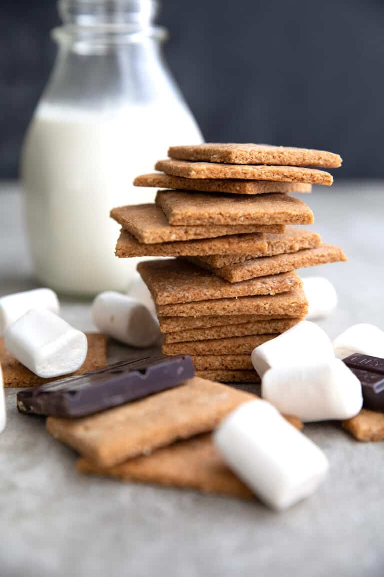 Sugar Free Graham Crackers in a stack with chocolate and marshmallows around it.