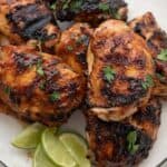 Top down image of Chipotle Lime Grilled Chicken on a white plate with limes.