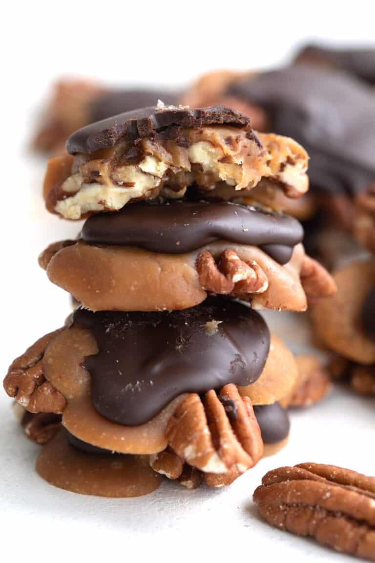 A stack of Keto Pecan Turtles on a white table.