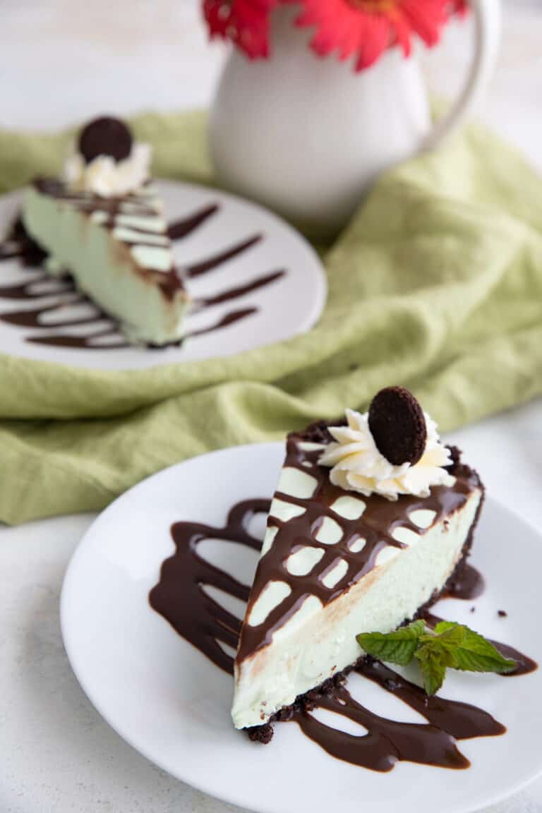 Two slices of Keto Grasshopper Pie on white plates with a green napkin.