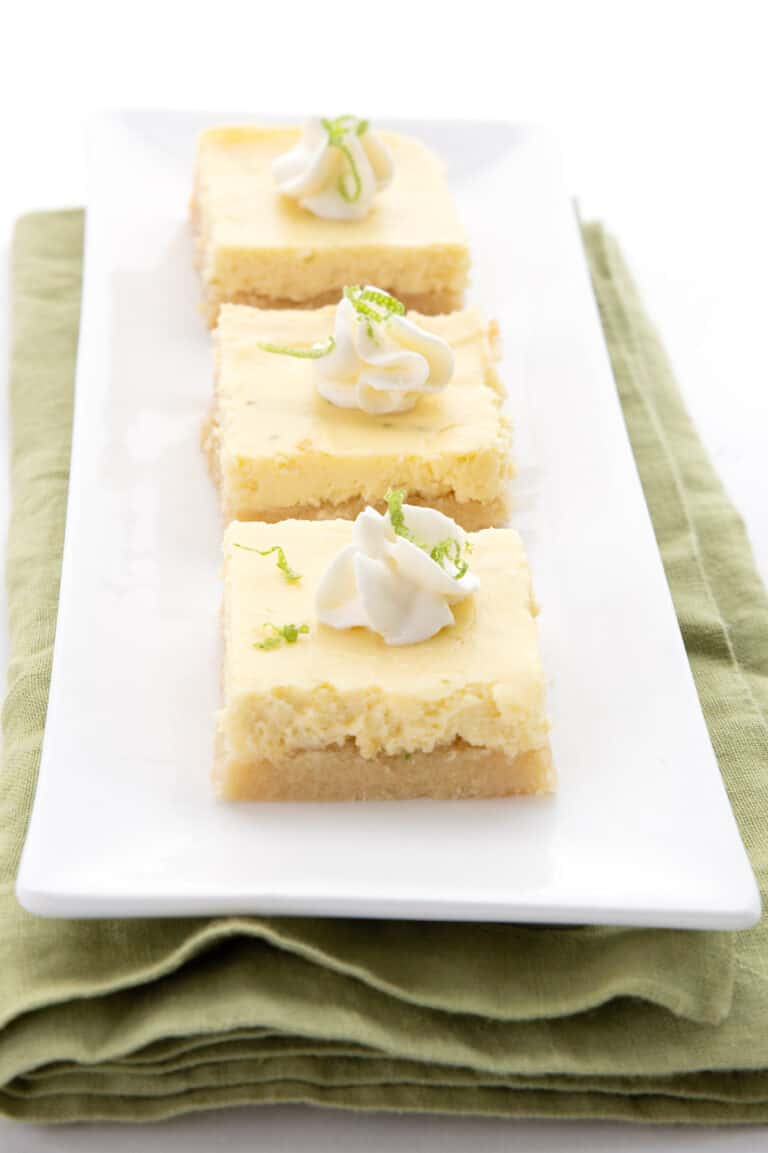 Three keto key lime bars on a white tray over a green napkin.