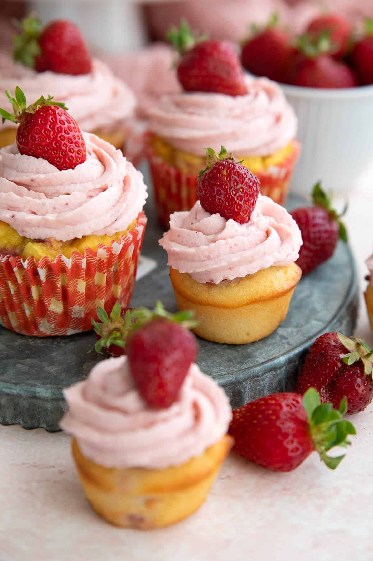 Keto Strawberry Cupcakes on a metal tray, with two mini cupcakes in front.