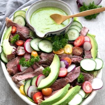 Chimichurri Steak Salad arranged on a large oval platter.