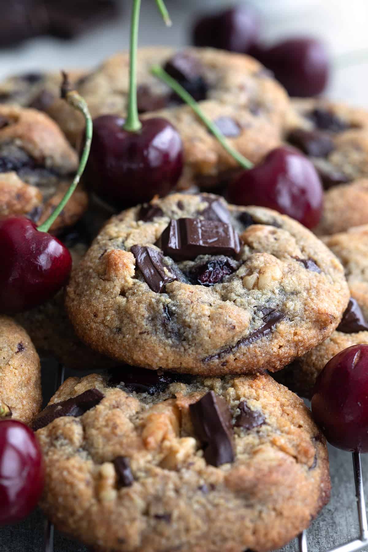 Close up shot of a pile of Cherry Chocolate Chunk Cookies on a cooling rack.