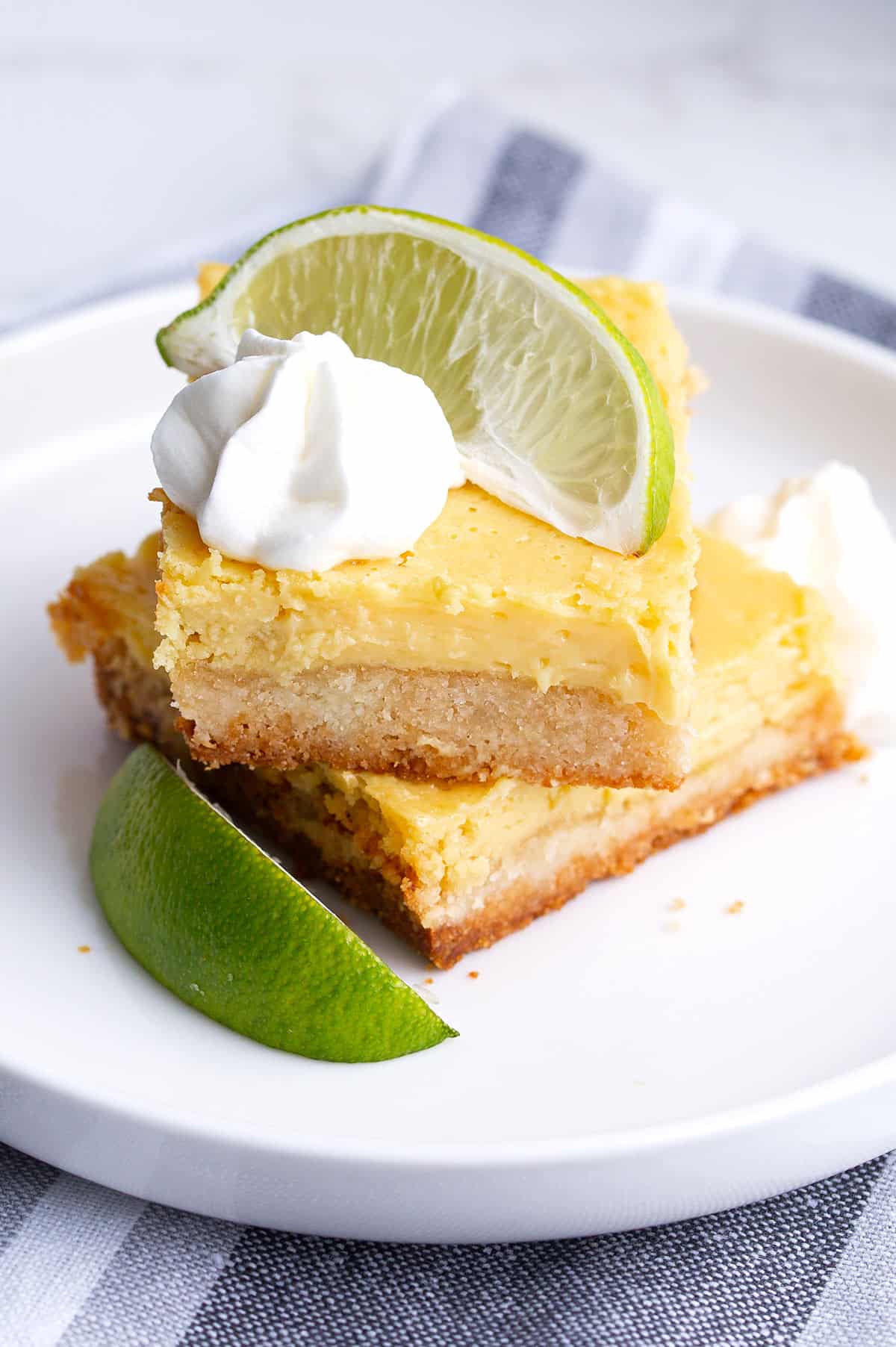 Two keto key lime bars piled on a white plate.
