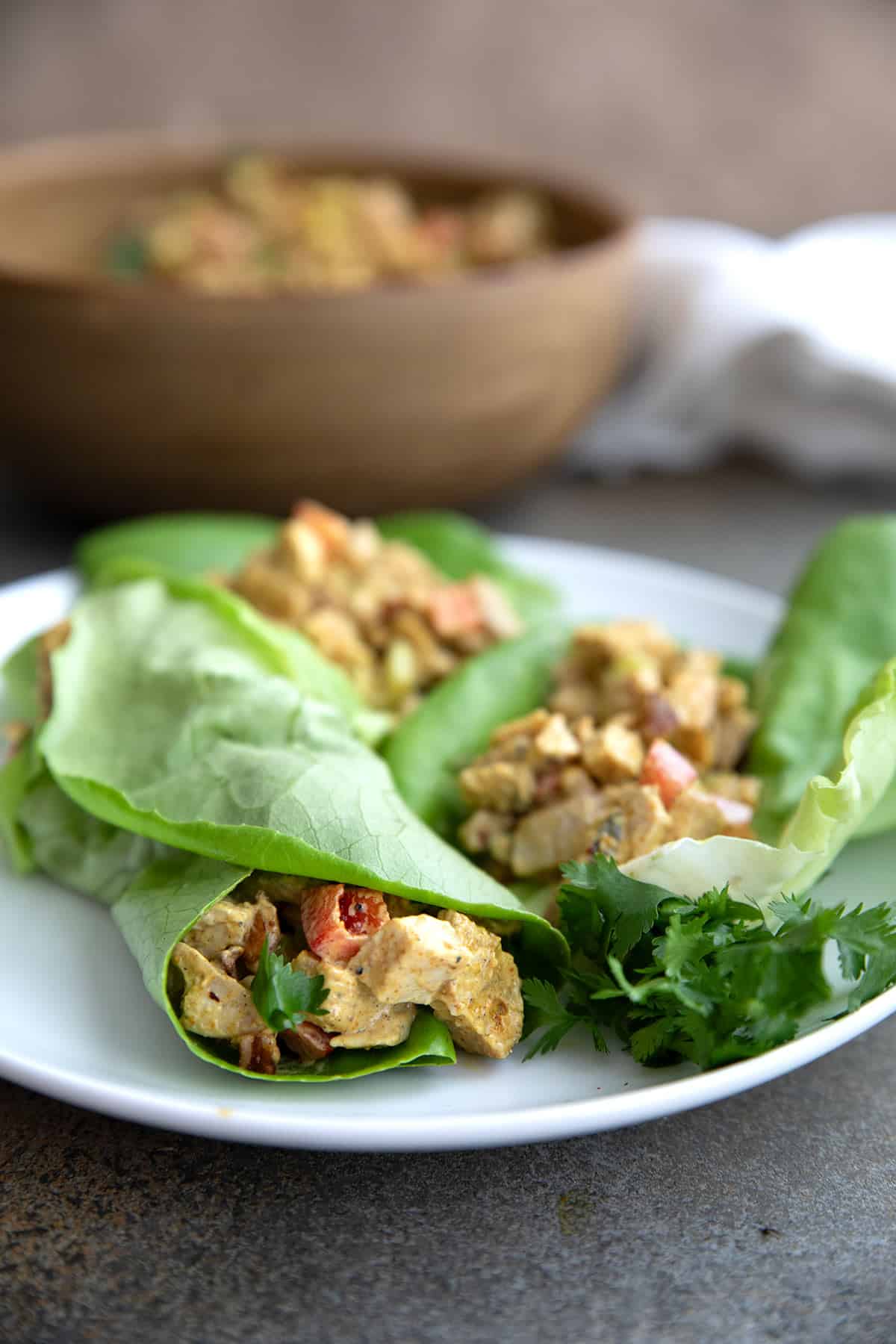 Keto chicken salad in lettuce wraps on a white plate.