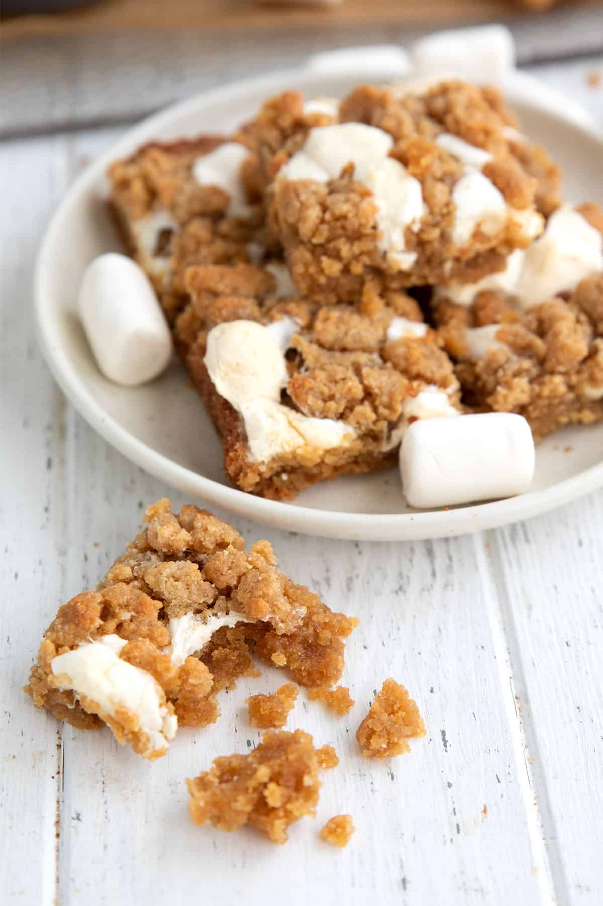 A Keto Fluffernutter Bar with a bite taken out of it on a white wooden table.