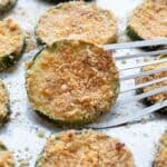 Titled Pinterst image of a metal spatula lifting zucchini parmesan from a sheet pan.