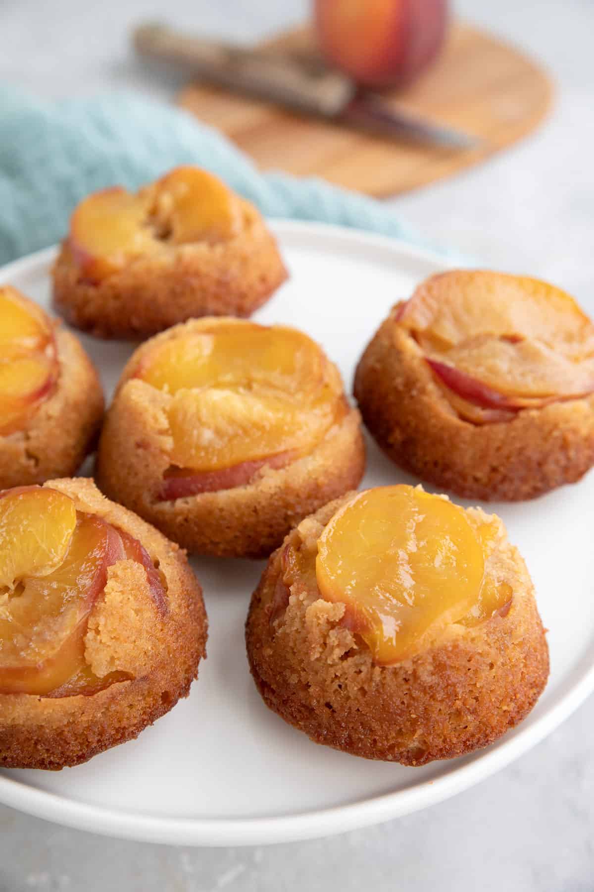 Keto Peach Upside Down Cakes on a white cake stand.