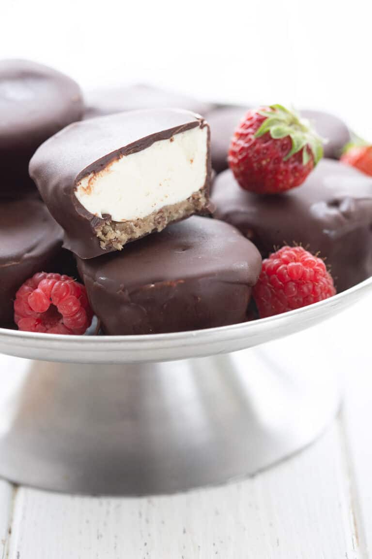 Keto Cheesecake Bites in a metal cake stand with fresh berries.