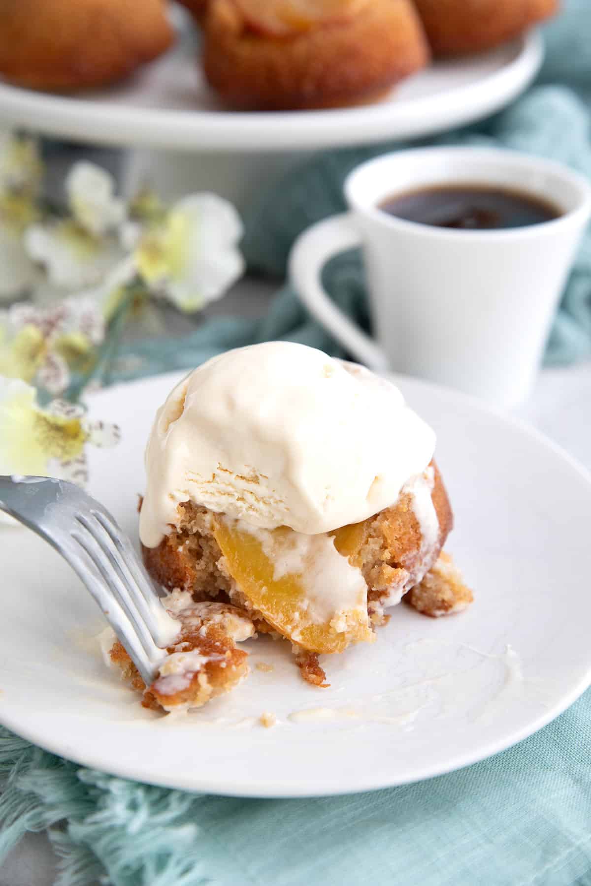 Keto Peach Upside Down Cake with vanilla ice cream on top and a forkful taken out of it.