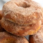 Titled Pinterest image of a stack of Keto Pumpkin Donuts on a wire cooling rack.