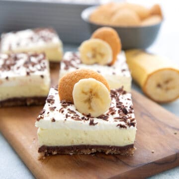 Keto Banana Cream Pie Bars on a wooden cutting board.