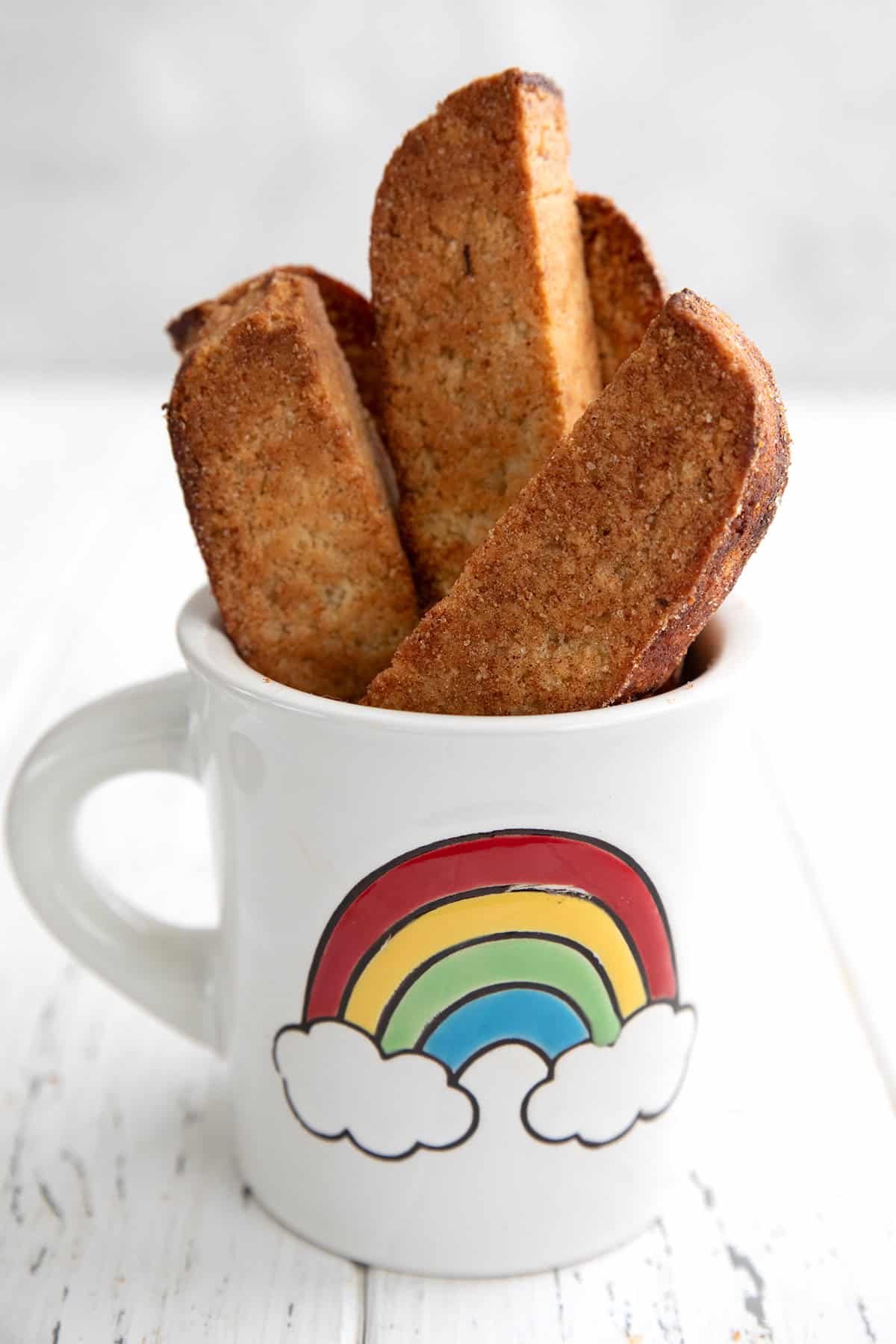 Keto Almond Flour Biscotti in a white mug with a rainbow on the front.