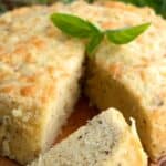 Titled image of a slice of keto instant pot bread on a cutting board in front of the loaf.