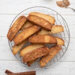 Top down image of keto biscotti on a cooling rack over a white wooden table.