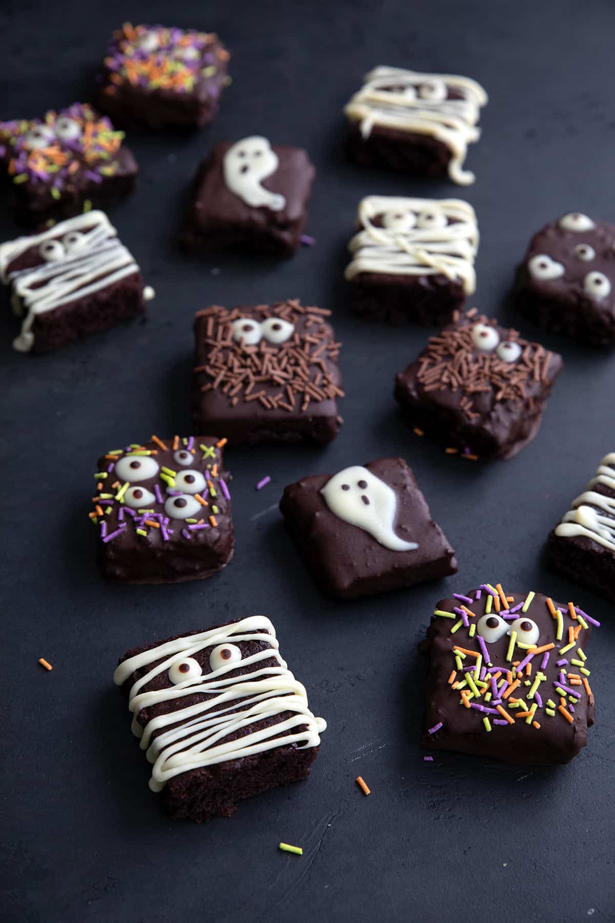 Keto Halloween Brownies spread out on a black tabletop.