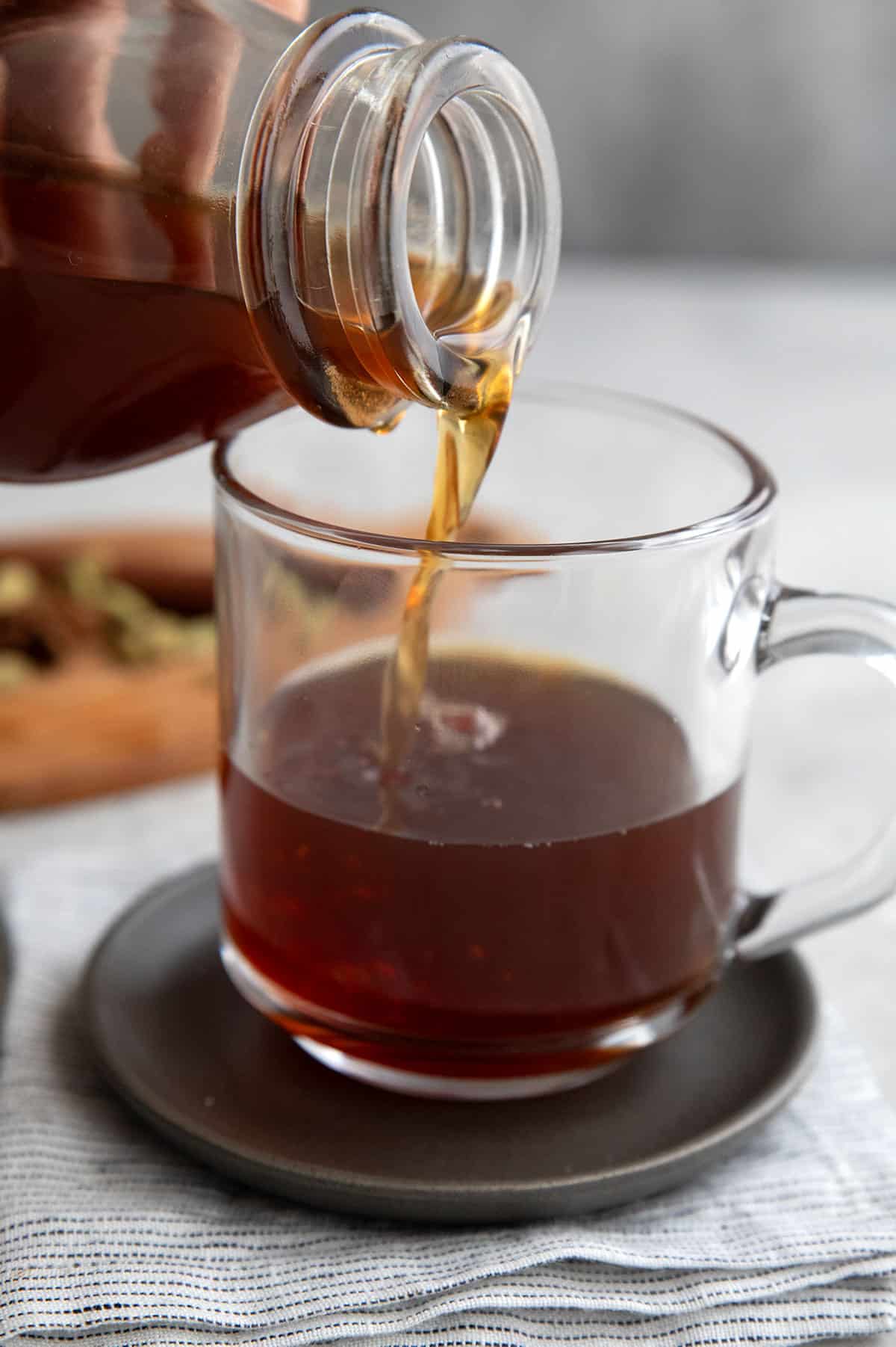 Sugar Free Chai Concentrate pouring from a bottle into a glass mug.
