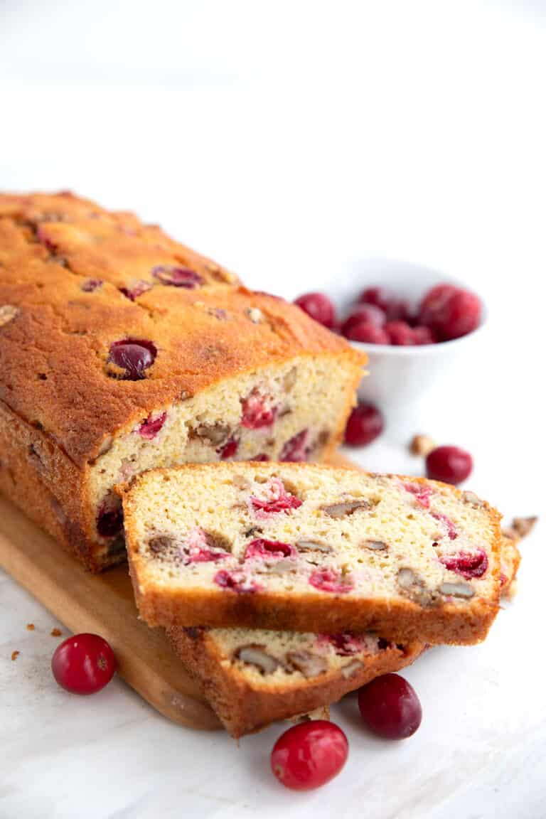 Keto Cranberry Orange Bread on a cutting board with two slices cut in front.