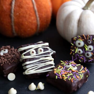 Keto Halloween Brownies decorated like mummies and monsters with pumpkins in the background.
