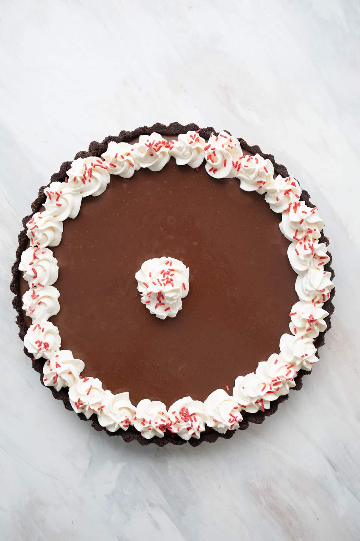 Top down image of Keto Chocolate Peppermint Tart on a marble tabletop.