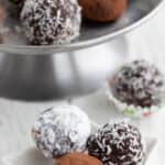 Titled image of three keto rum balls on a small star-shaped plate. One rolled in cocoa powder, another in powdered sweetener, and the third in shredded coconut.