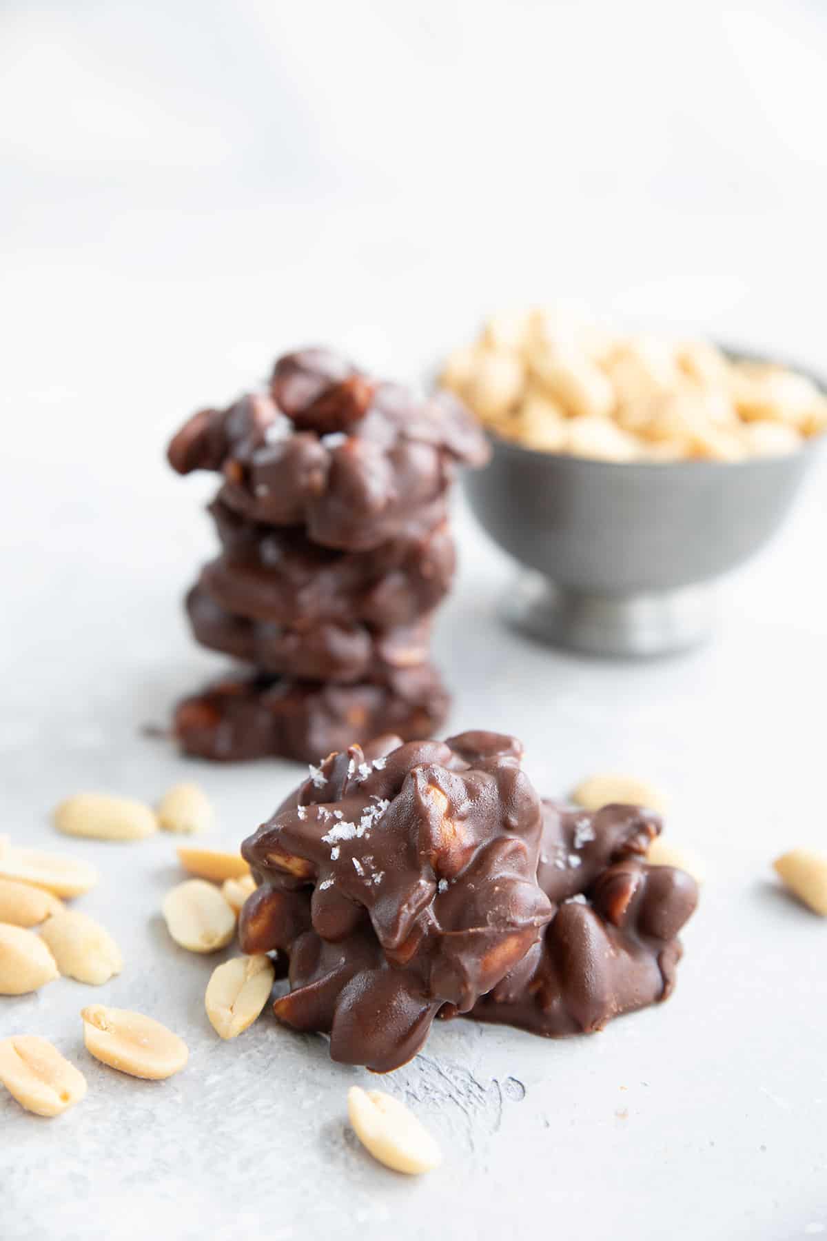 Two Keto Peanut Clusters in front of a stack of more clusters.