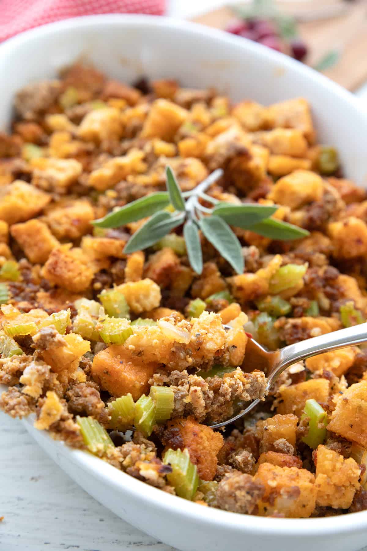 Close up shot of keto Thanksgiving stuffing in the dish with a spoon digging into it.