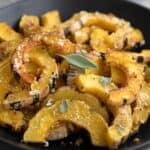 Titled image of a black bowl filled with parmesan roasted delicata squash.