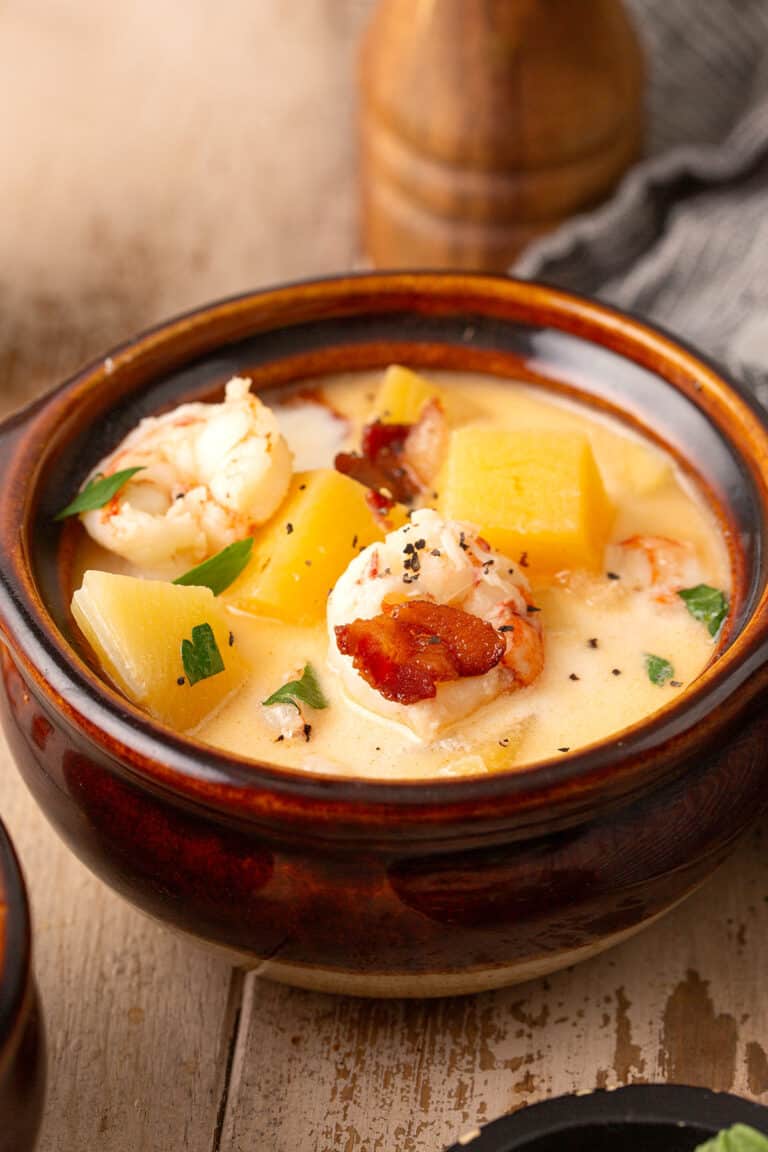 Close up shot of shrimp chowder in a rustic brown bowl.