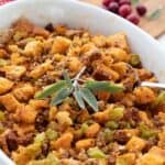 Titled image of Keto Holiday Stuffing in a white oval dish with a sprig of sage on top.