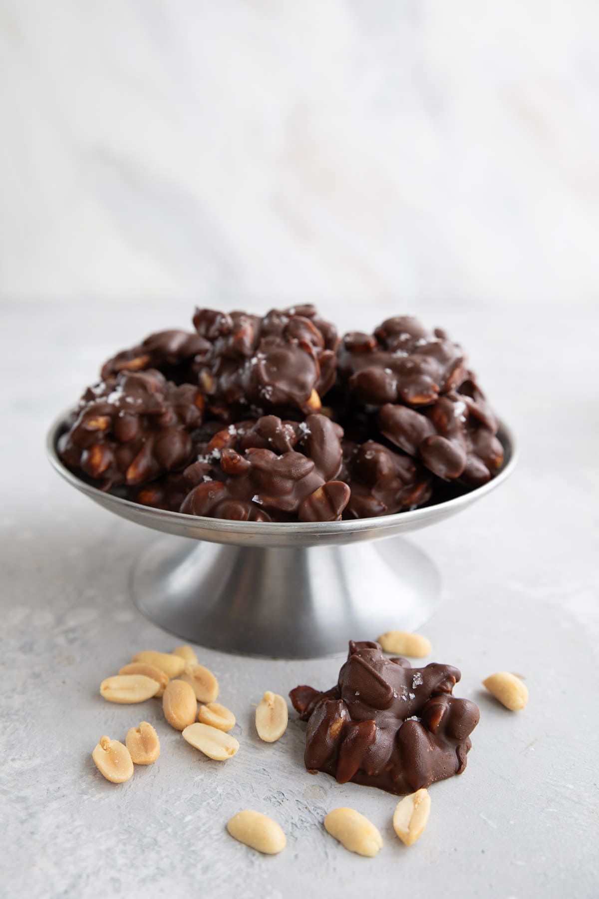 A metal candy dish filled with Keto Peanut Clusters.
