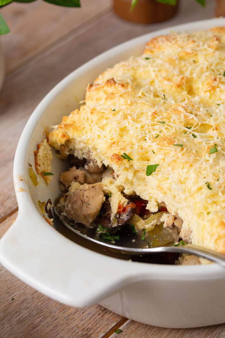 A spoon digging into a large baking dish of Keto Chicken Pot Pie.