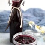 Titled image of a jar of blueberry syrup with a bottle of syrup in behind it.