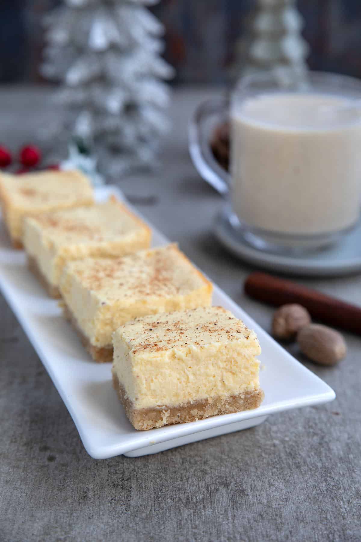 Keto Eggnog Cheesecake Bars on a white rectangular platter.