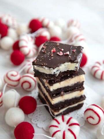 A stack of Keto Peppermint Bark Brownies with a bite taken out of the top one.