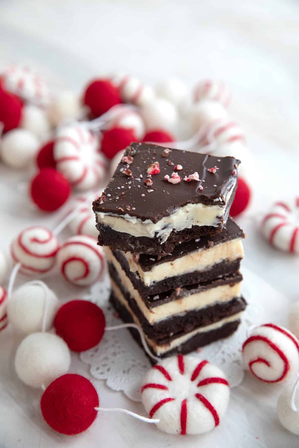 A stack of Keto Peppermint Bark Brownies with a bite taken out of the top one.