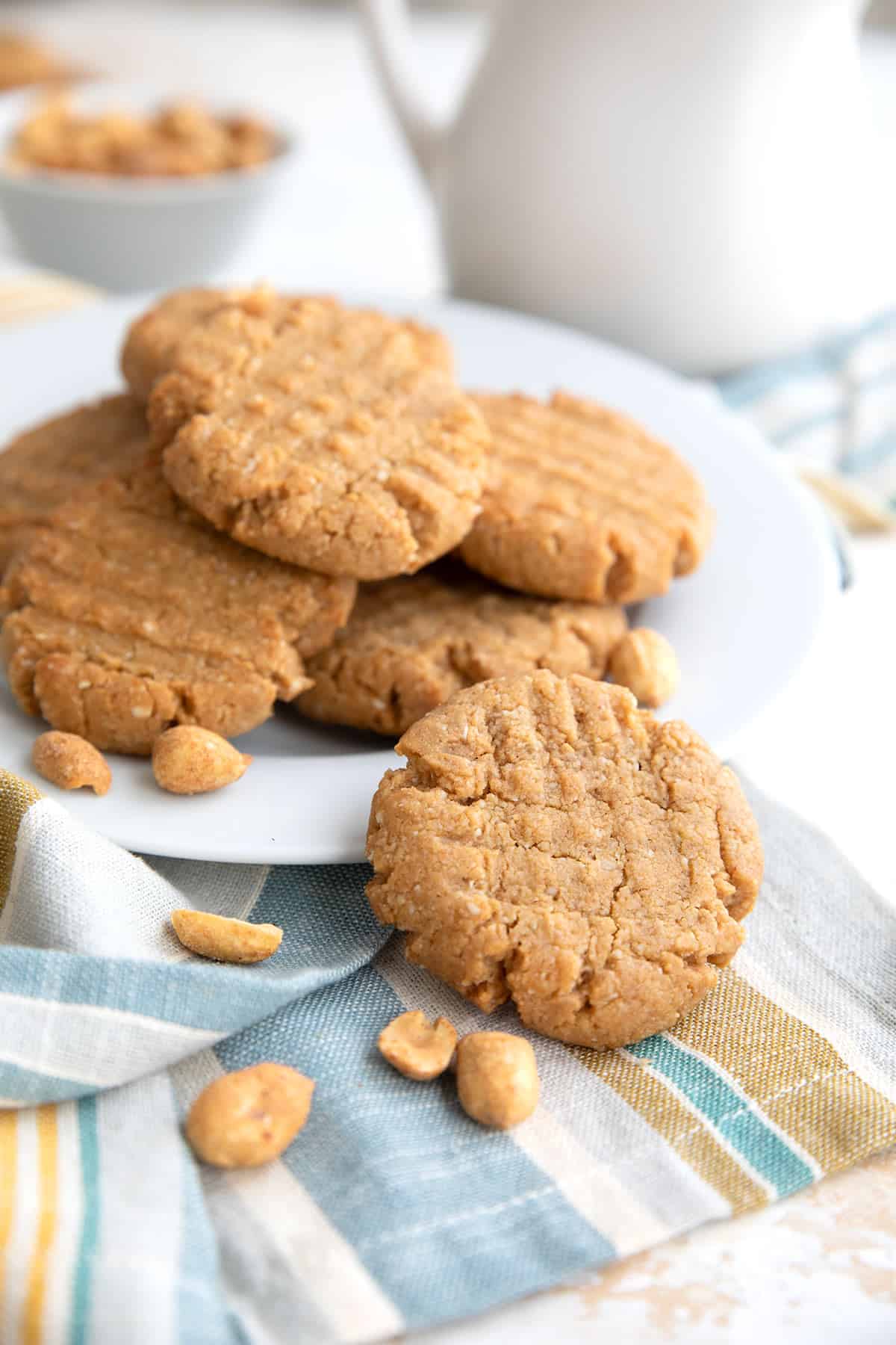 A white plate filled with Keto Peanut Butter Cookies on a striped napkin.