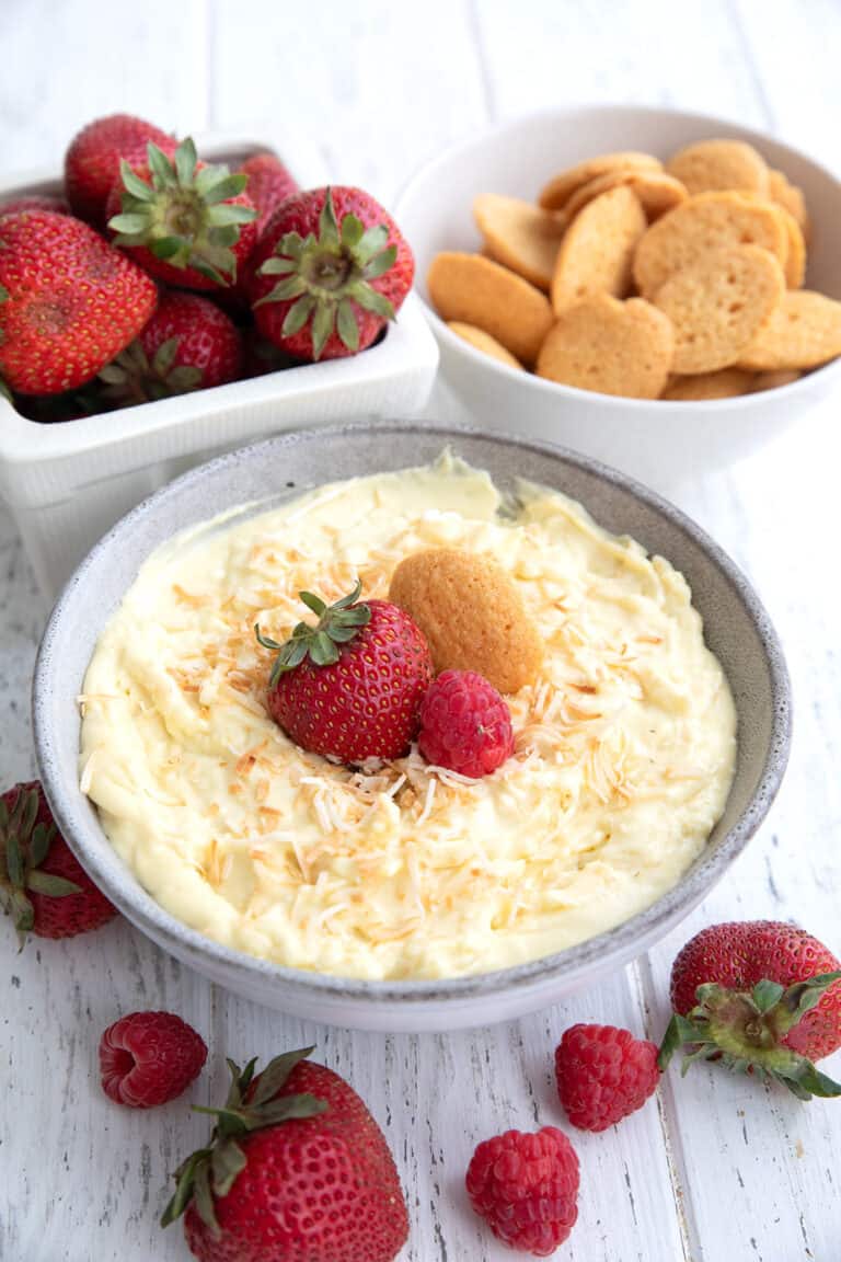 Coconut Cream Pie Dip in a gray bowl on a white wooden table.