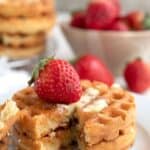 Keto waffles on a white plate with a bite cut out of them, with the title "21 High Protein Low Carb Breakfast Recipes".